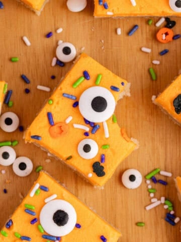 Halloween Sugar Cookie Bars with orange icing, sprinkles and eyeballs close up