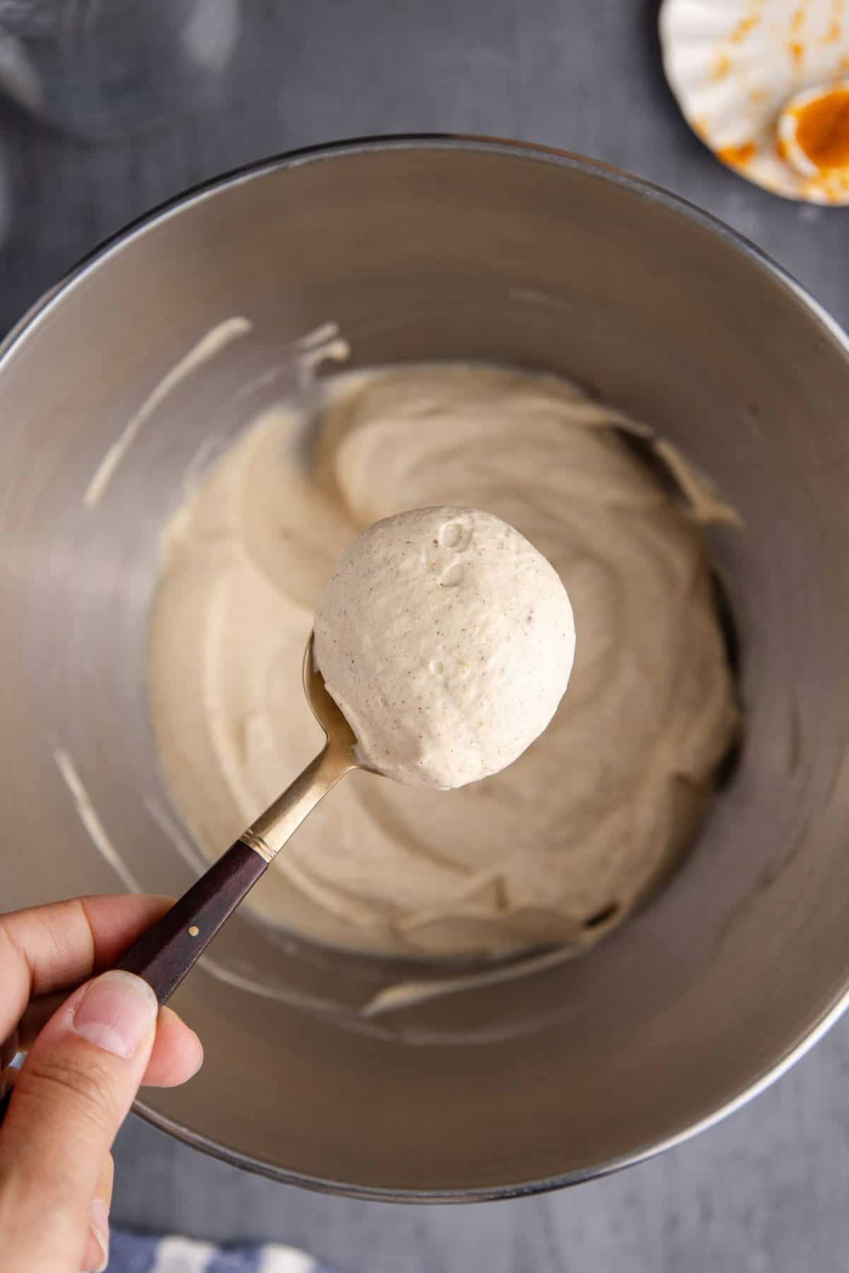 Pumpkin Cold Foam overtop of a mixer bowl on a spoon