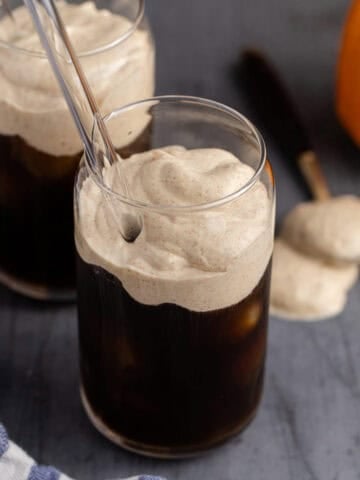 Pumpkin Cold Foam in a glass overtop of iced coffee