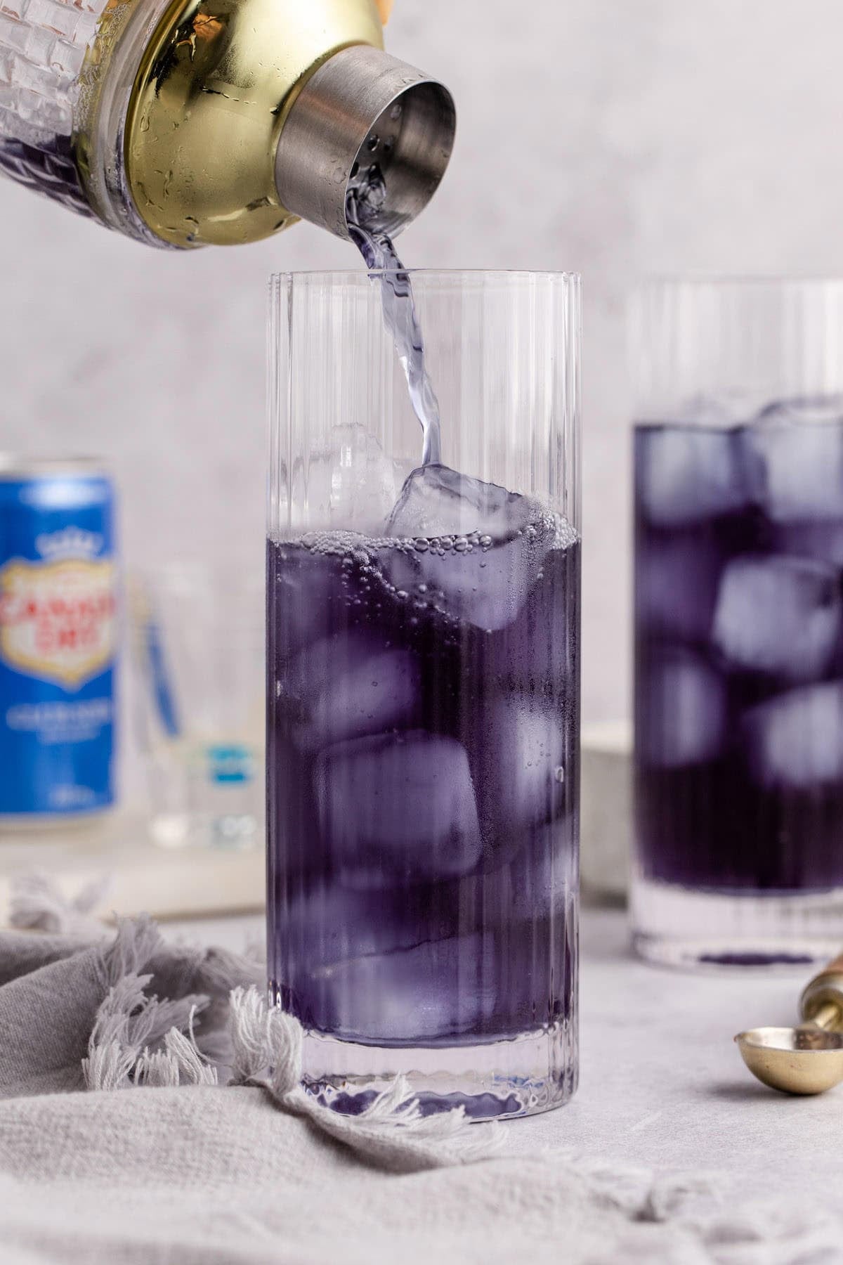Purple Rain Cocktail bing poured into a tall glass