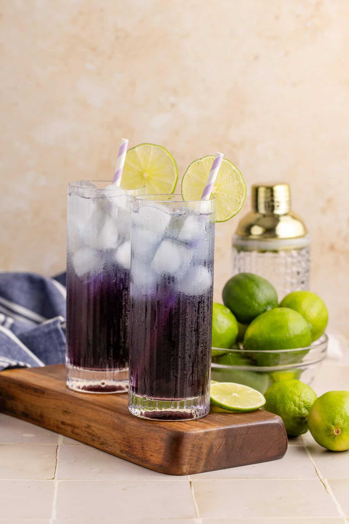 Purple Rain Cocktail on a cutting board with a shaker behind