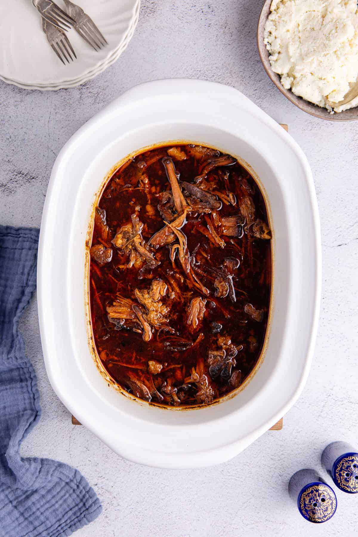 Slow Cooker Brisket shredded in the base of the cooker right after complete