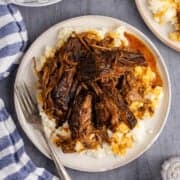 Slow Cooker Brisket shredded on top of mashed potatoes