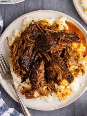 Slow Cooker Brisket shredded on top of mashed potatoes
