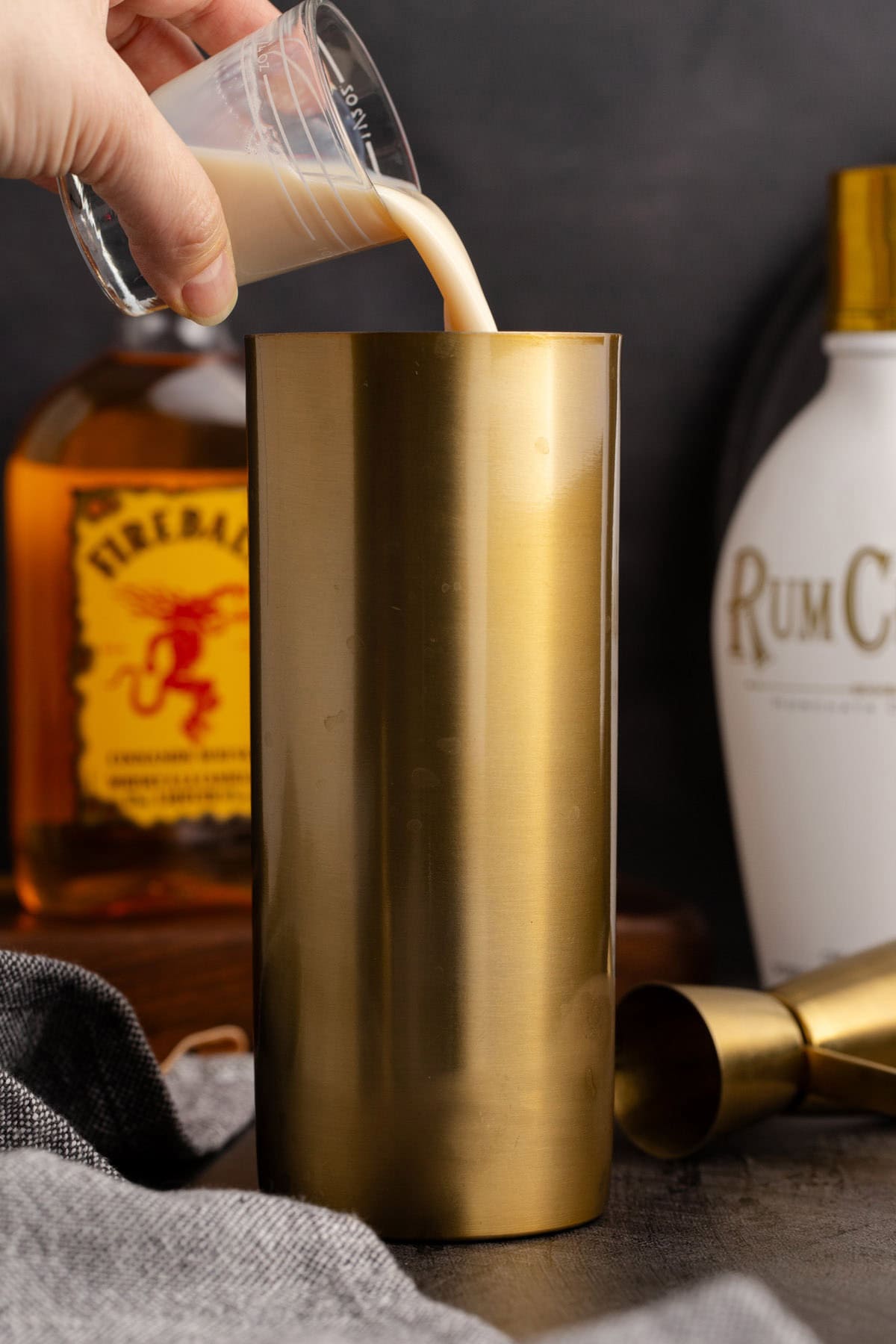 Cinnamon Toast Crunch Shot being made by pouring RumChata in a cocktail shaker