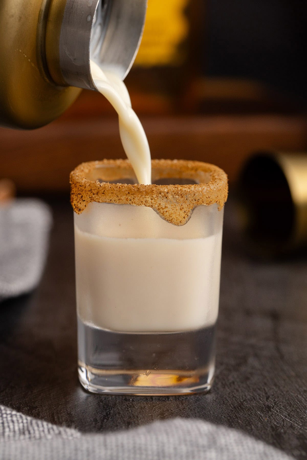 Cinnamon Toast Crunch Shot being poured into a cinnamon rimmed shot glass
