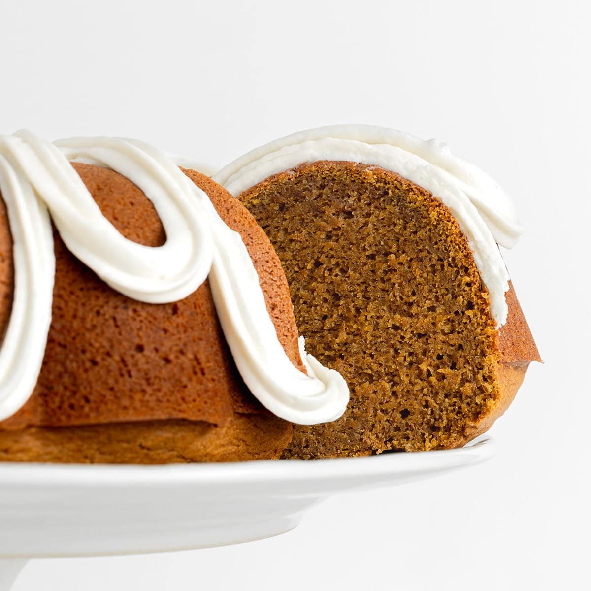 Gluten Free Pumpkin Bundt Cake with thick swirls frosting
