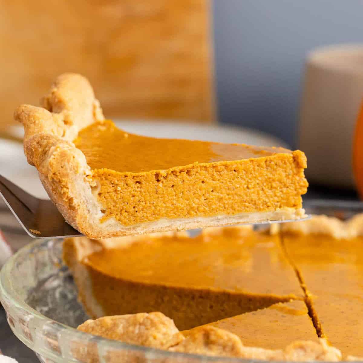 A slice of Pumpkin Pie on a server being lifted up