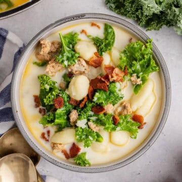Zuppa Toscana in a bowl close up with bacon for garnish