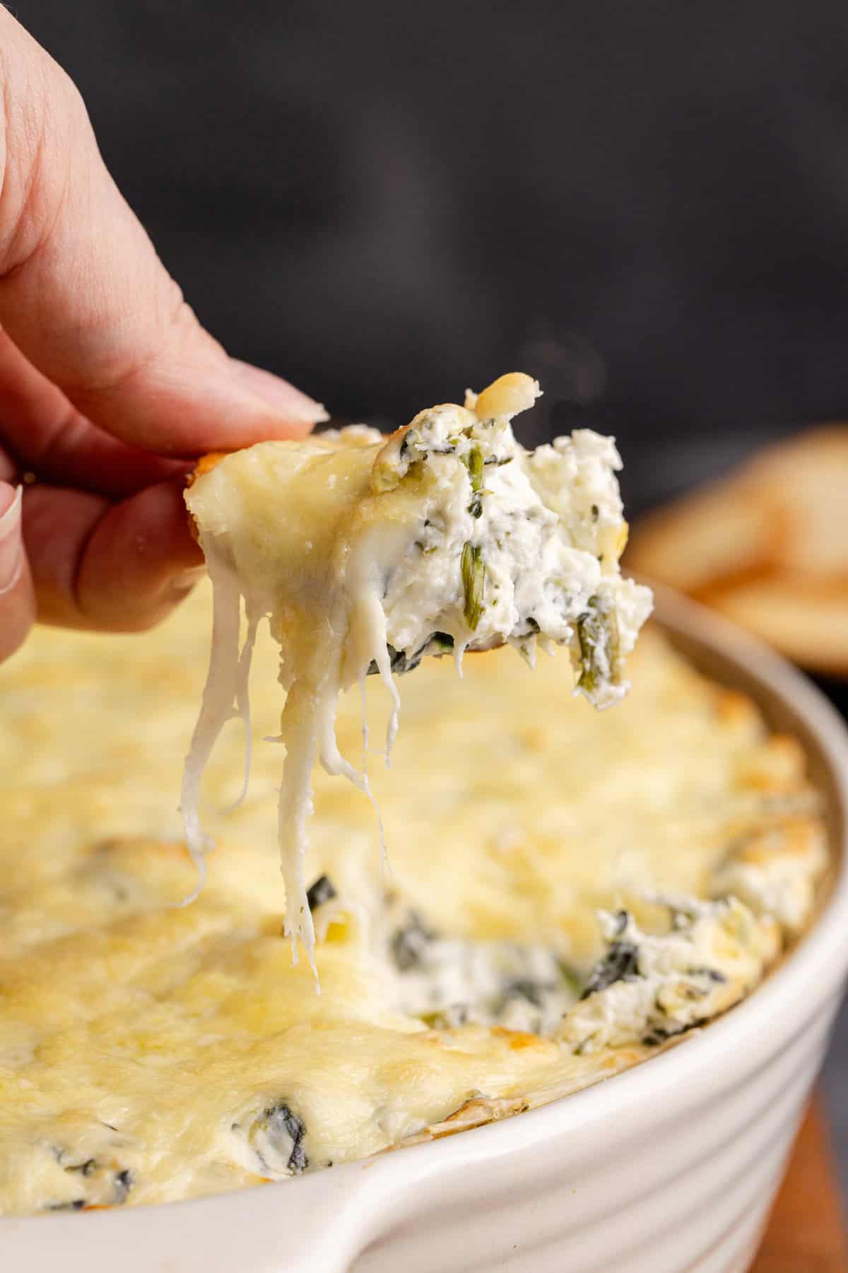 Baked Spinach and Artichoke Dip Scooped with a Cracker