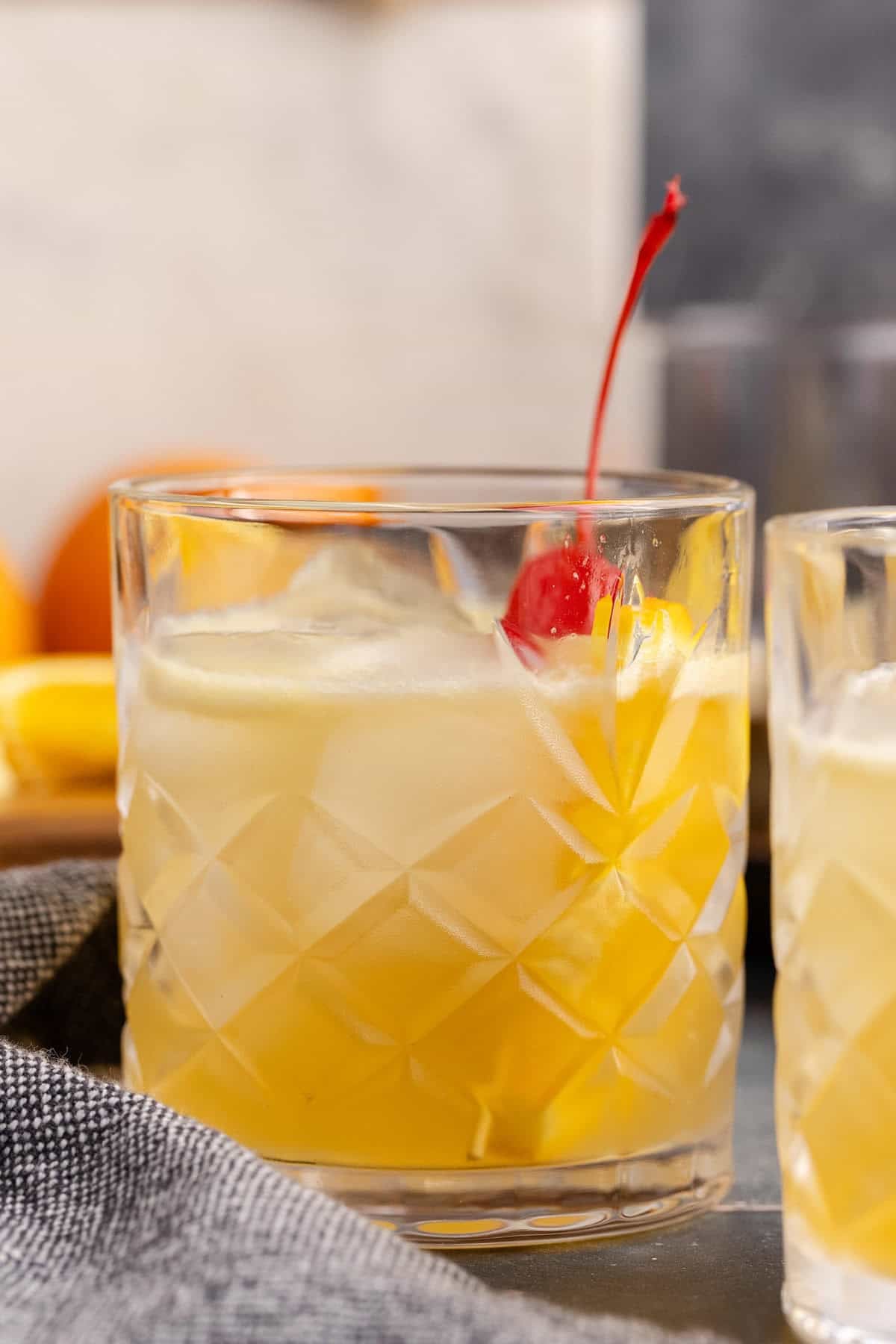 Bourbon Lemon Cocktail in a Glass Garnished with a Maraschino Cherry and Lemon Wedge