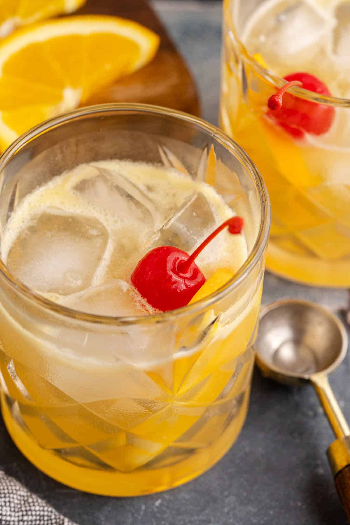 Bourbon Lemon Cocktail in a Glass Garnished with a Maraschino Cherry and Lemon Wedge Close Up