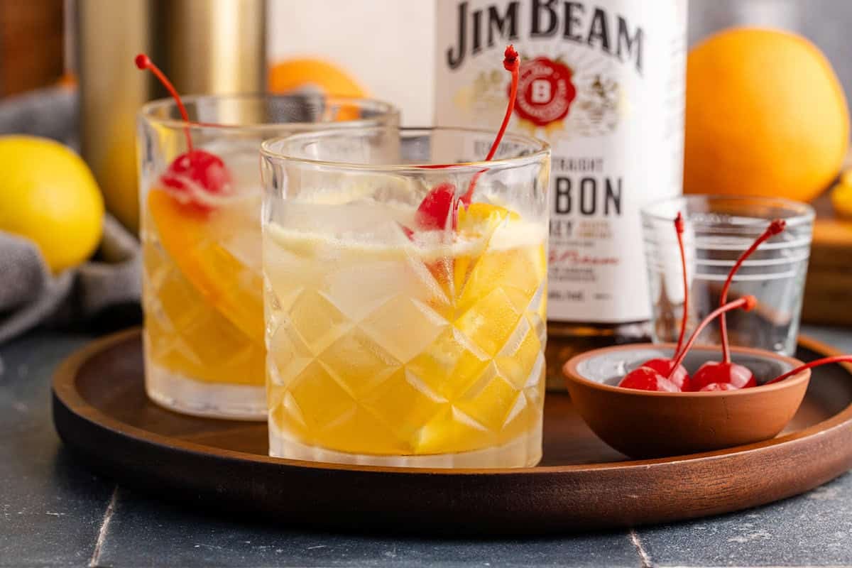 Bourbon Lemon Cocktails in Glasses on a Tray with Maraschino Cherries
