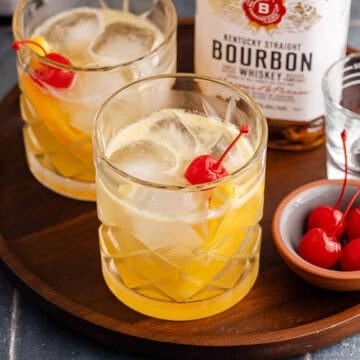 Bourbon Lemon Cocktails in Glasses on a Tray with Maraschino Cherries