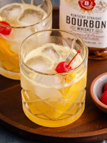 Bourbon Lemon Cocktails in Glasses on a Tray with Maraschino Cherries
