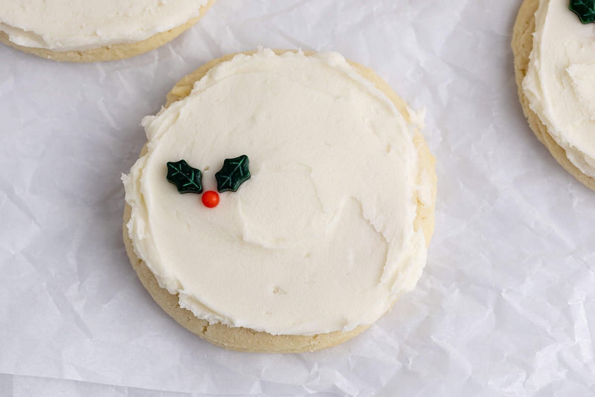 White Buttercream Frosting on Sugar Cookie with Holly Berry Sprinkles