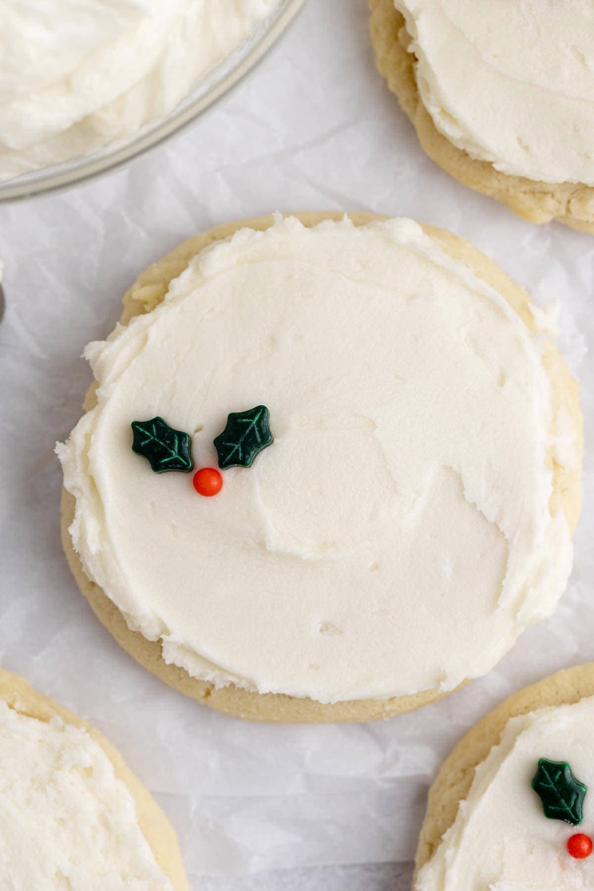 White Buttercream Frosting on Sugar Cookie with Holly Berry Sprinkles