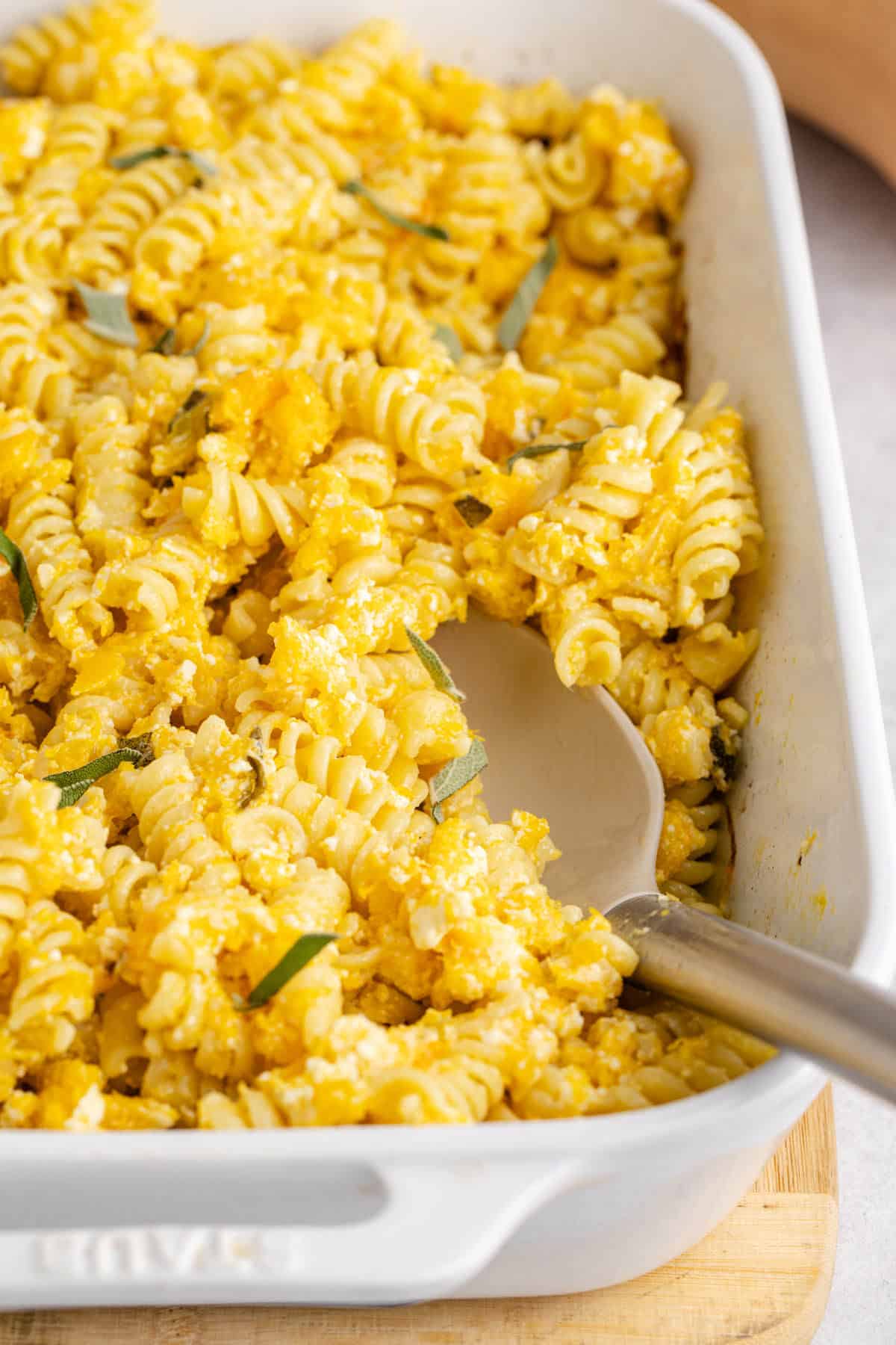 Butternut Squash Feta Pasta in a baking dish with a serving spoon