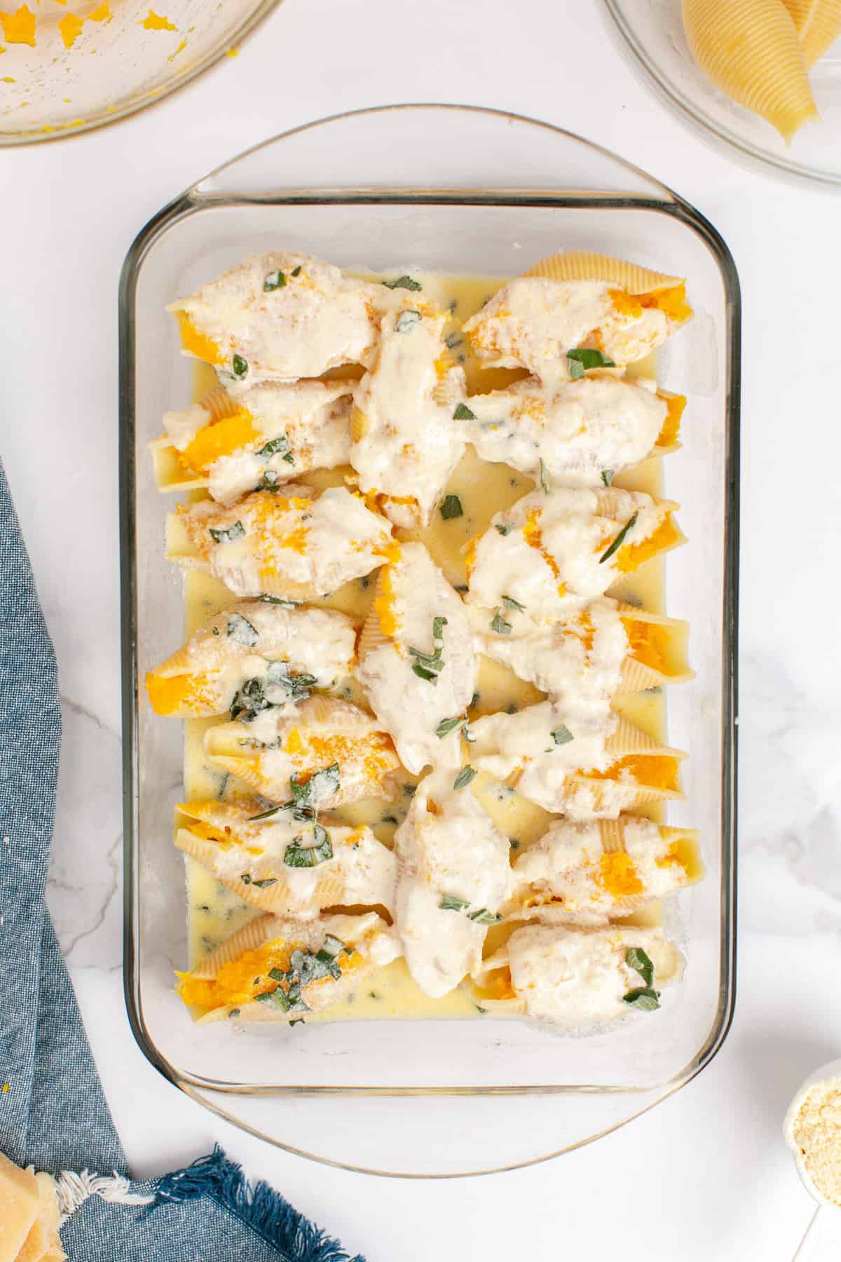 Butternut Squash Stuffed Shells in a Baking Dish Covered in Creamy Sage Sauce