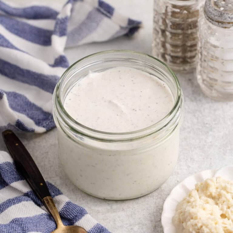 Creamy Horseradish Sauce in a mason jar from above with horseradish on a small plate beside
