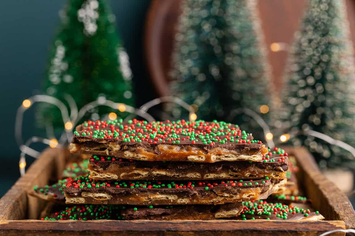 Easy Christmas Crack Recipe stacked with christmas trees in the background