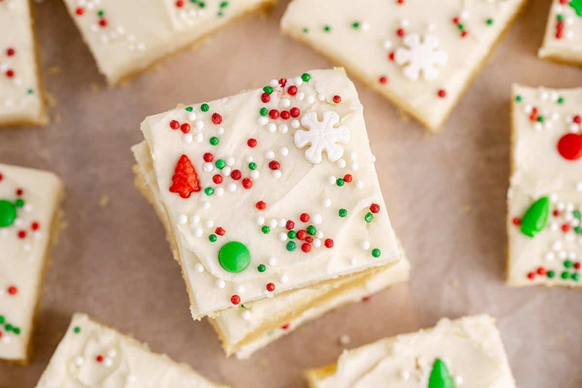 Frosted Sugar Cookie Bars stacked on parchment paper