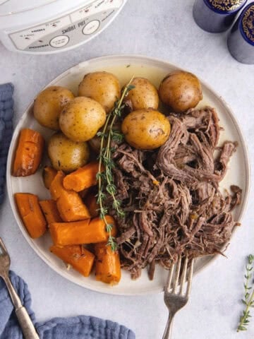 Pot Roast Slow Cooker Recipe all shredded on plate with carrots and potatoes