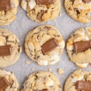Smores Cookies baked on a cookie sheet with graham crumbs and a Hershey square on top