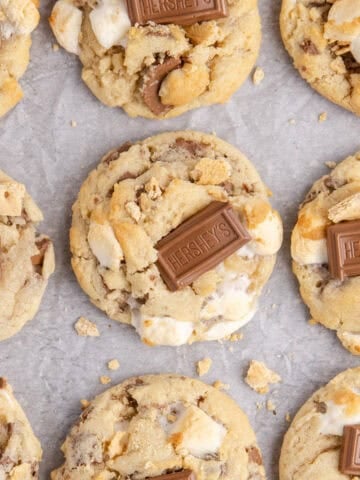 Smores Cookies baked on a cookie sheet with graham crumbs and a Hershey square on top