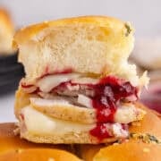 Stacked Turkey Sliders on Hawaiian Rolls Topped with Melted Cheese and Cranberry Sauce