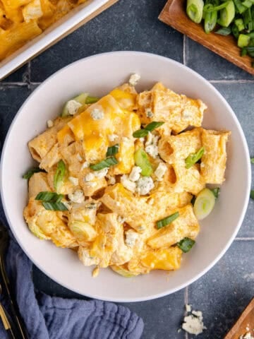 Buffalo Chicken Casserole from above in a bowl with blue cheese crumbles and green onions
