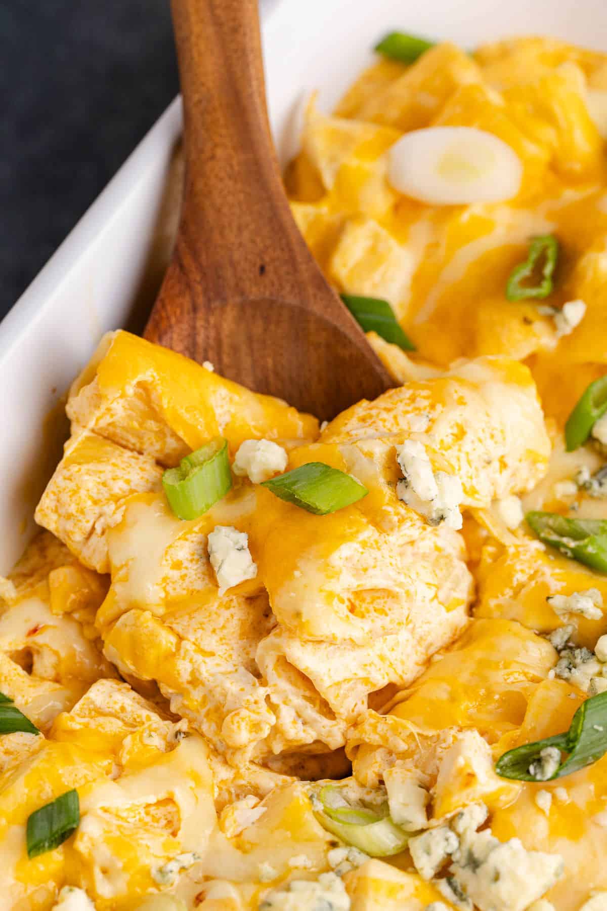 Buffalo Chicken Casserole being scooped on a spatula from freshly baked baking dish