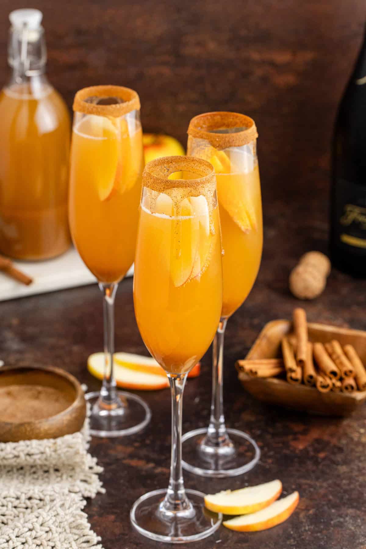 Apple Cider Mimosas Served in Flute Glasses with Cinnamon Sugar Rim and Fresh Apple Slice Garnish