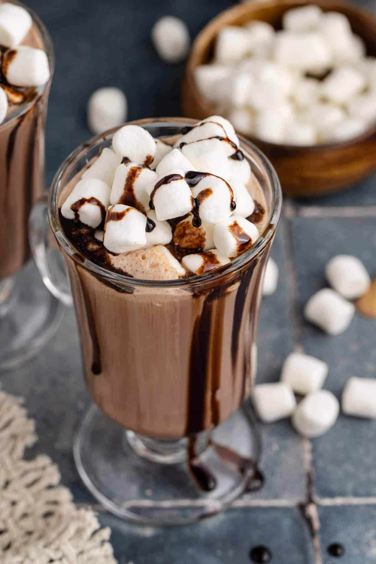 Baileys Hot Chocolate Served in Glass Mug Topped with Mini Marshmallows and Chocolate Sauce Drizzle