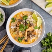 Coconut Curry Chicken Soup served in bowls with garnishes around