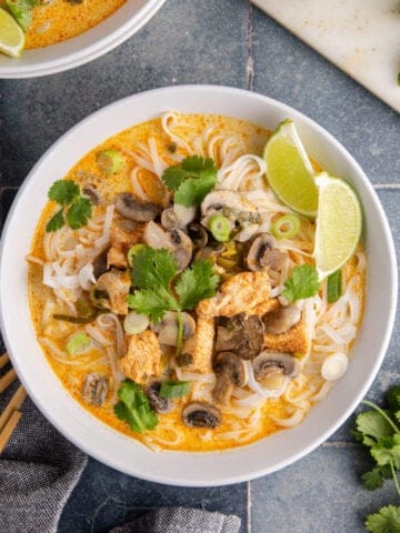 Coconut Curry Chicken Soup served in bowls with garnishes around