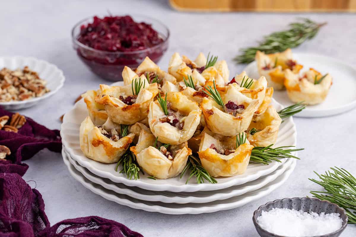 Plate of Cranberry Brie Bites Stacked and Garnished with Fresh Rosemary