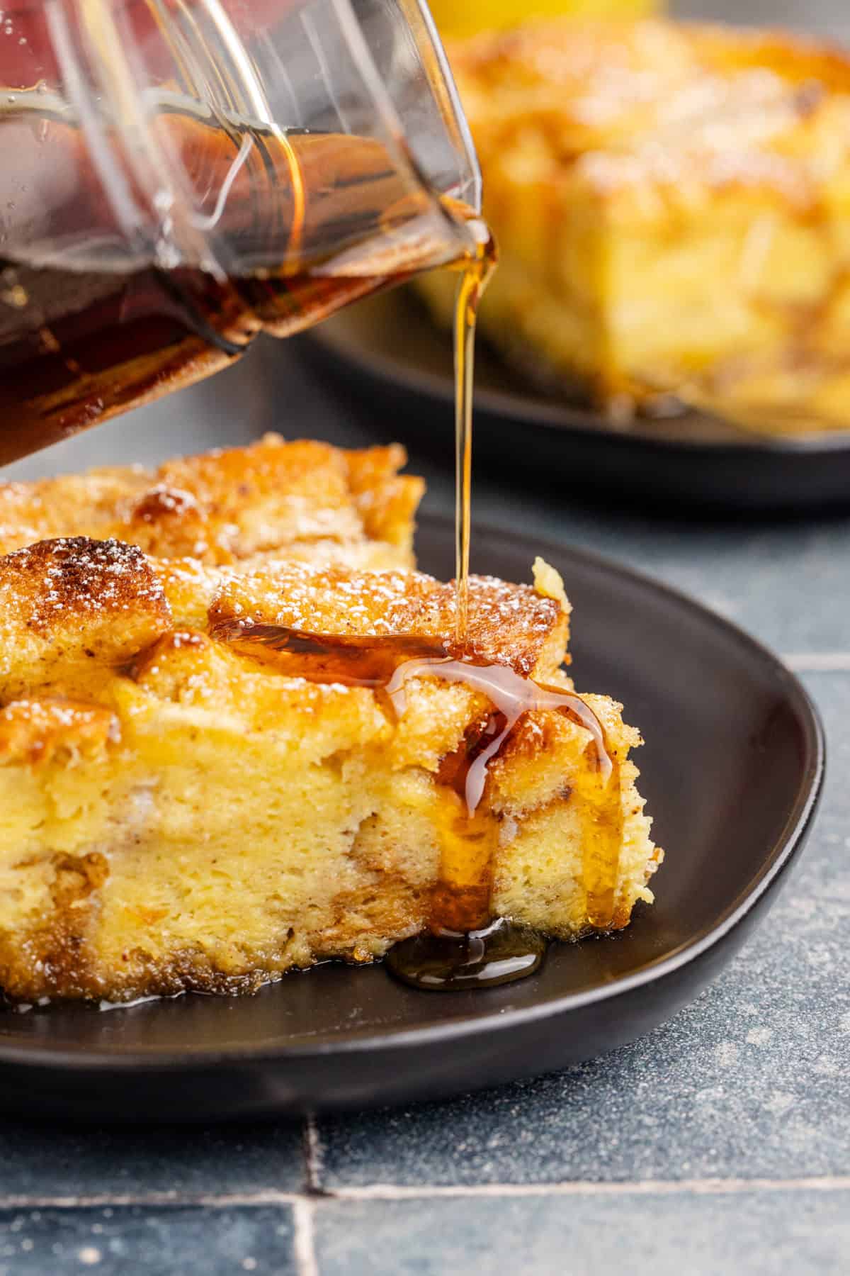 Eggnog Recipes Baked French Toast with Eggnog served on a plate with syrup being poured