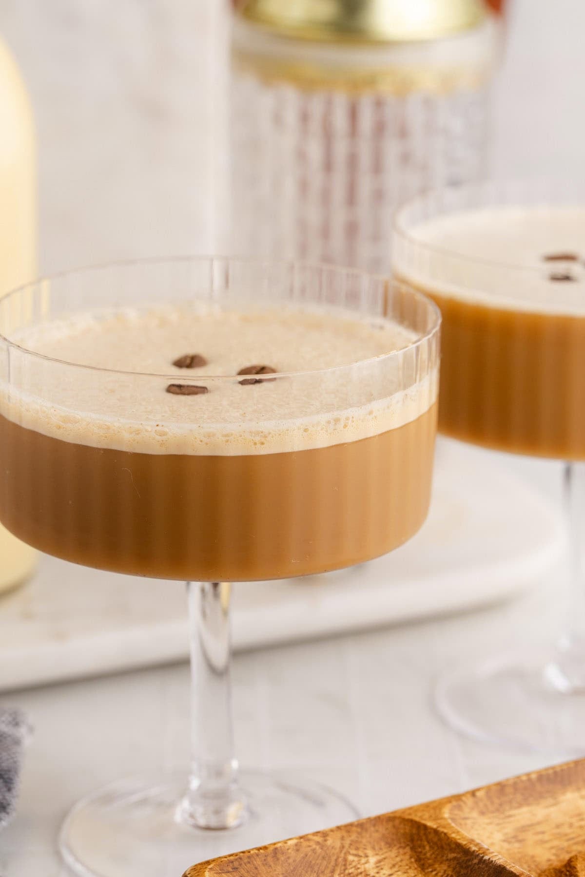 Eggnog Recipes Espresso Martini in a glass with a cocktail shaker in the back