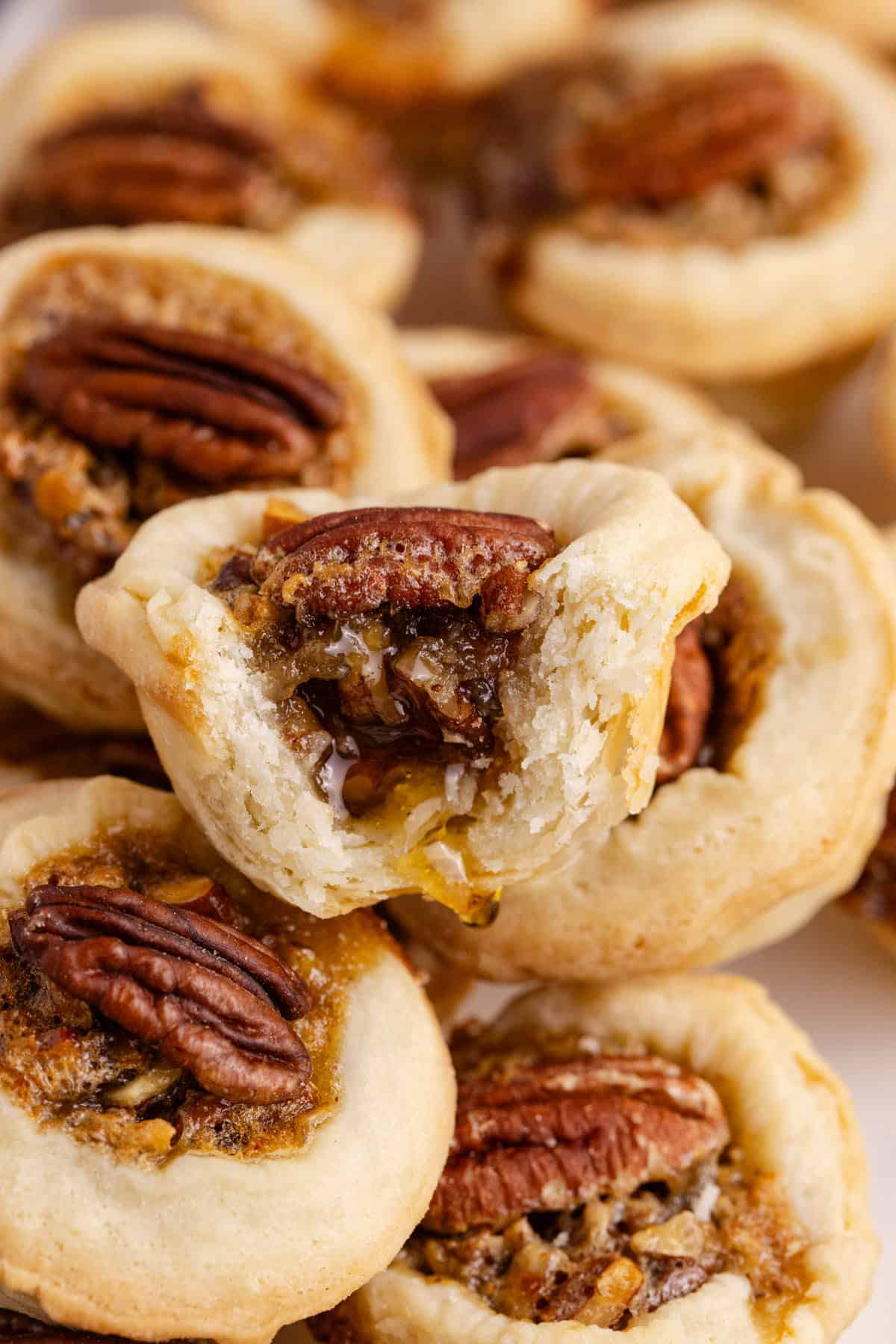 Mini Pecan Pies stacked with a bite taken of one