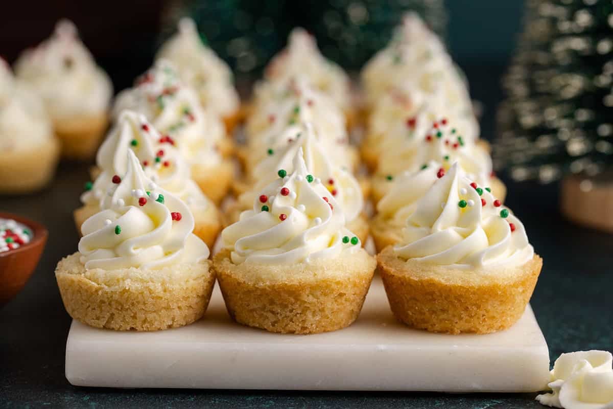 Sugar Cookie Cups on a tray with Frosting and Christmas Sprinkles