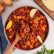Overhead of Sweet Potato Skillet with Fresh Parsley and Lemon Wedge Garnishes