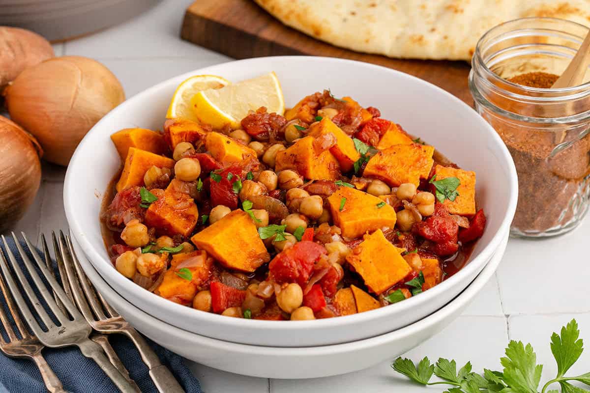 Sweet Potato Skillet Served in a Bowl and Garnished with Parsley and Lemon Wedge