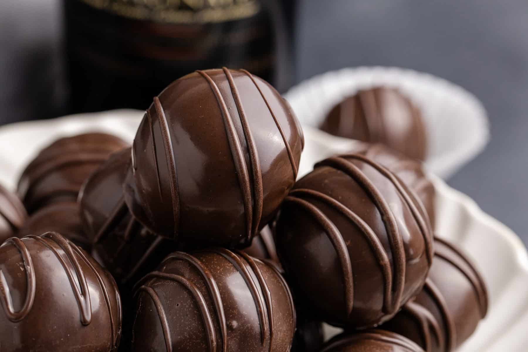 Baileys Truffles on a plate with a bottle of baileys in the back