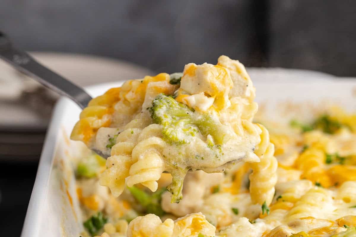 Cheesy Chicken Casserole in a casserole dish with a spoonful being taken out
