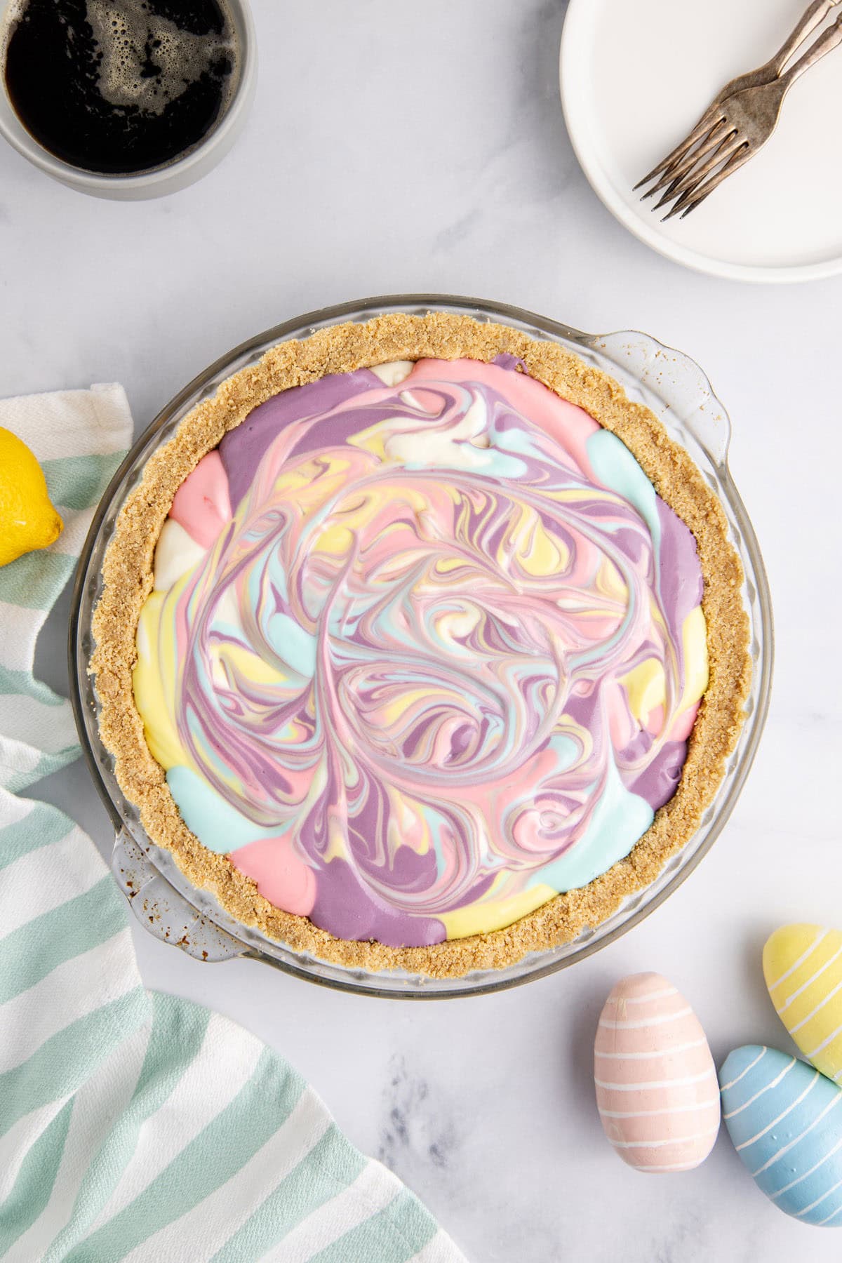 Easter Swirl Cheesecake from above on a counter with a plate and coffee