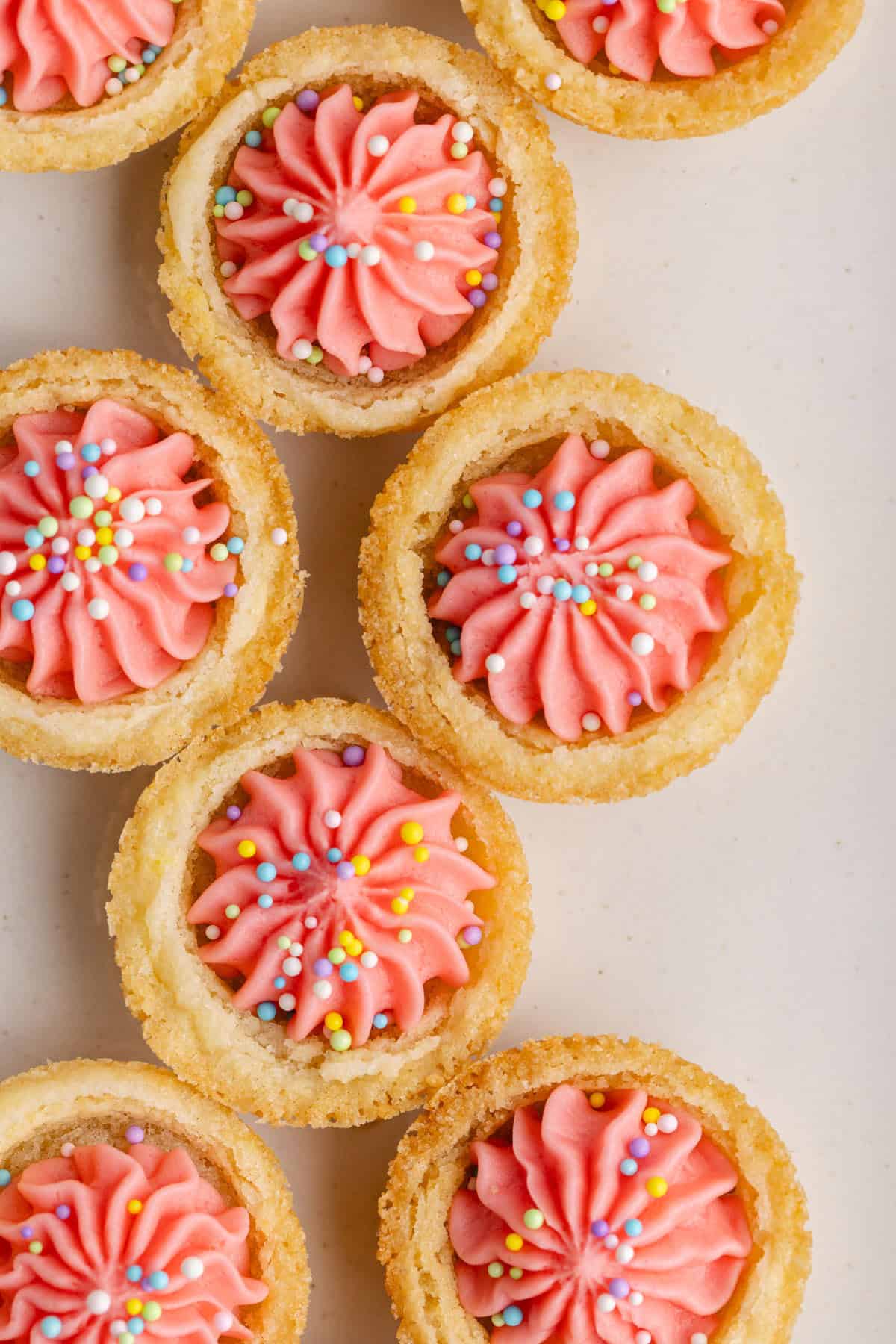 Easter Sugar Cookie Cups with pink icing and sprinkles from above on a platter