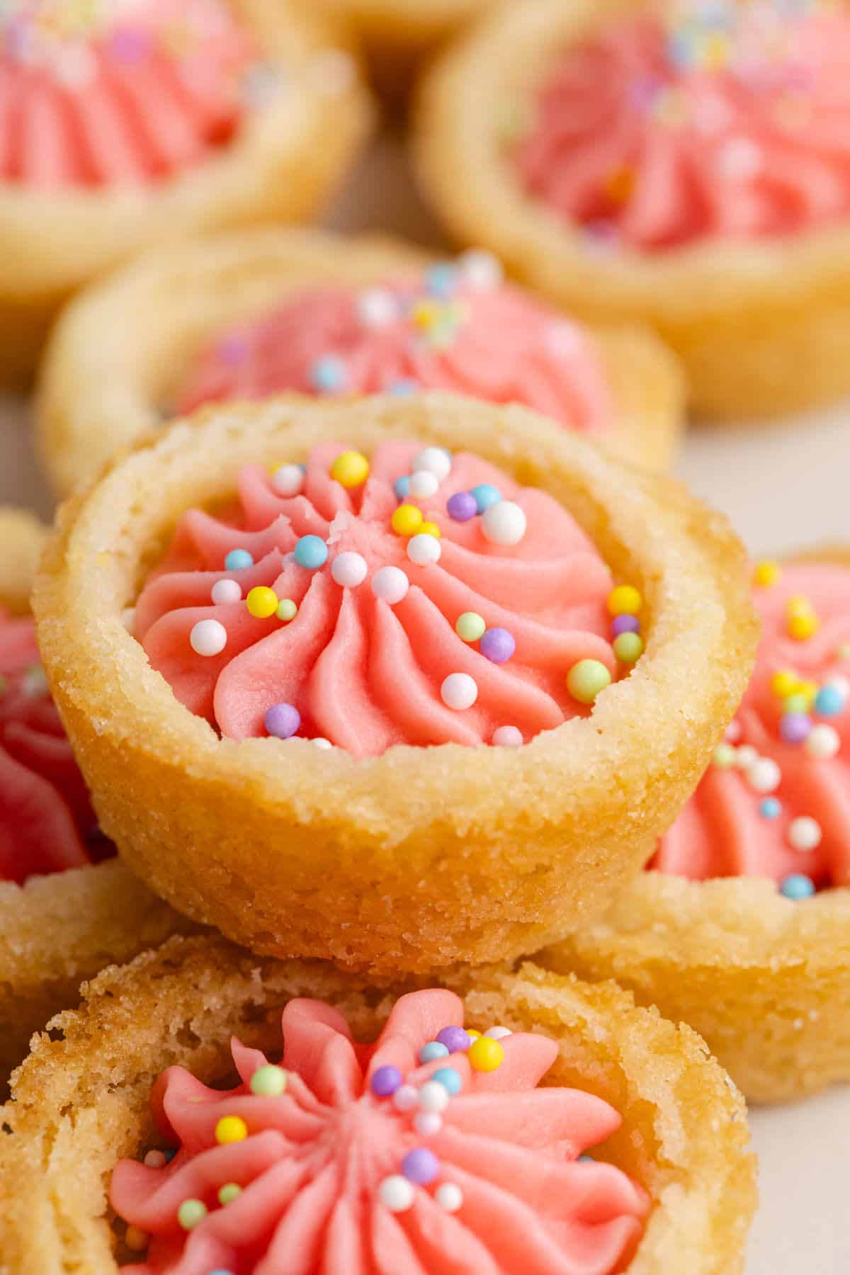 Easter Sugar Cookie Cups with pink icing and sprinkles