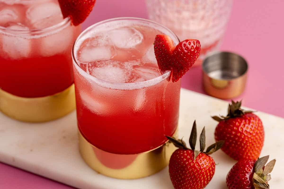 Love Bug Cocktails on a cutting board with a strawberry heart garnish