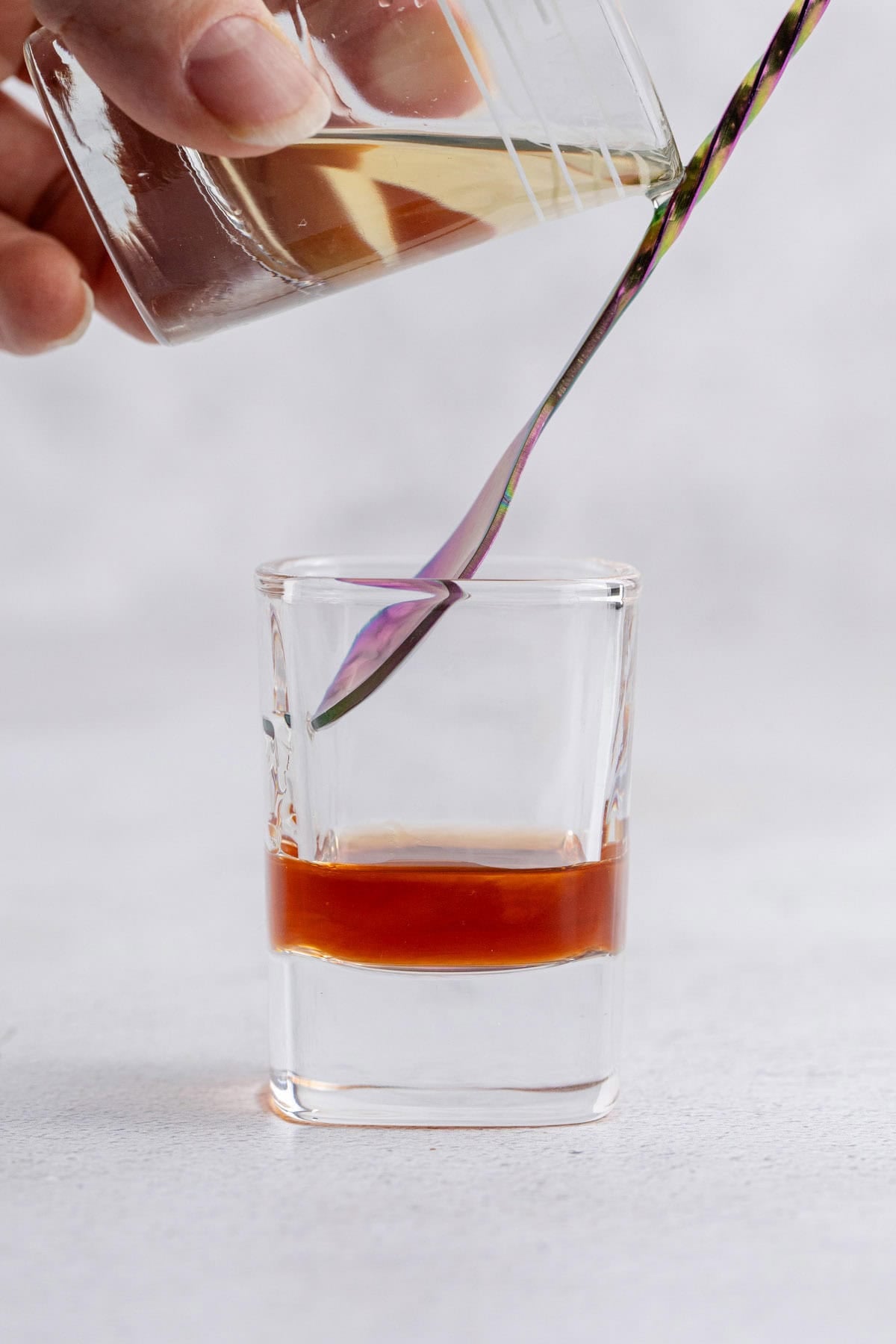 Peanut Butter and Jelly Shot being made with a cocktail spoon for layering